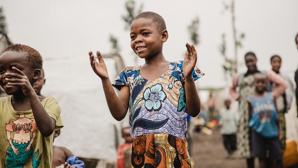 Gentille spielt mit ihren Freund*innen im Kazimba Camp für binnenvertriebene Familien in DRC.