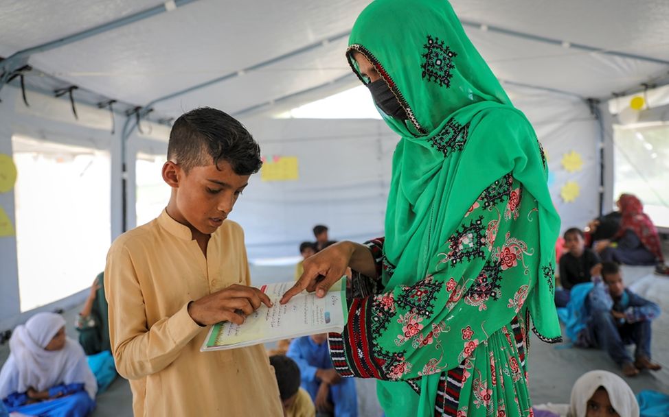 Pakistan 2022: Daniyal lernt mit seiner Lehrerin Fazia und seinen neuen Schulbüchern.