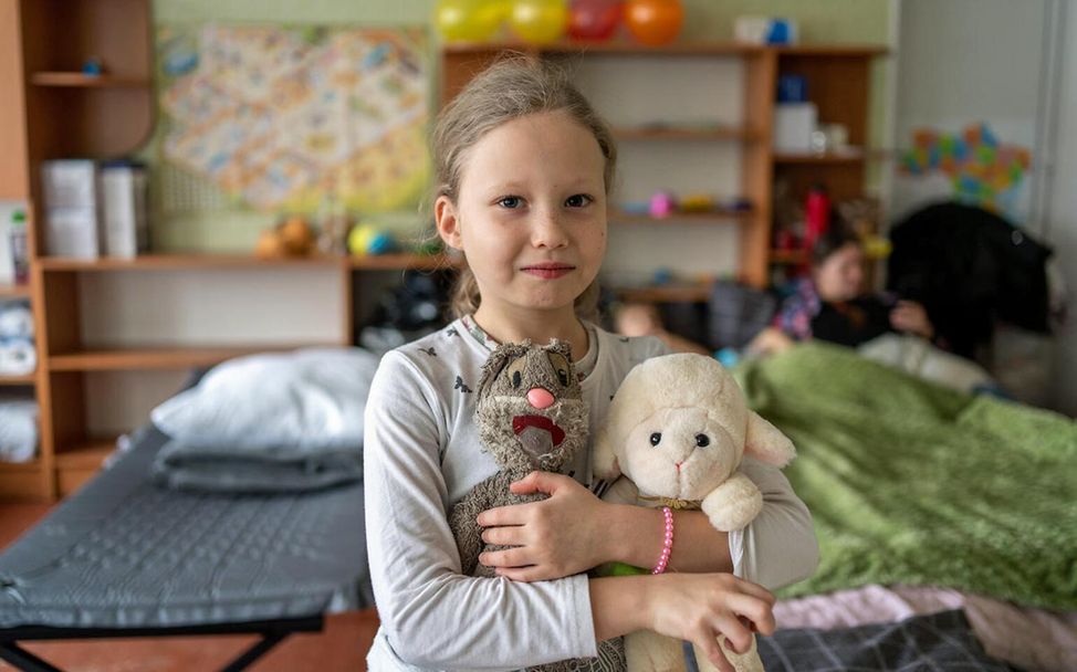 Ukraine Spenden: Ein geflüchtetes ukrainisches Mädchen hält ihre Stofftiere fest im Arm