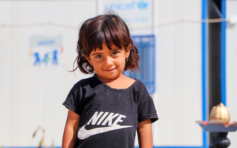 Weltflüchtlingstag: Sahar, 3, steht am vor dem von UNICEF unterstützten Zentrum für frühkindliche Bildung in Syrien