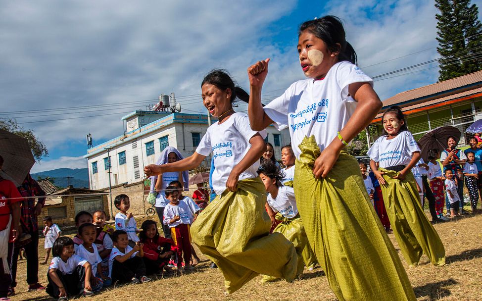 Myanmar: Kinder spielen Sackhüpfen.