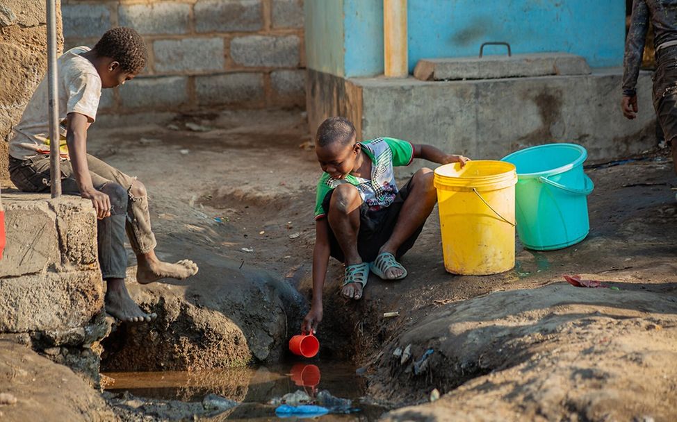 Dürre Kinder: In Sambia schöpfen zwei Jungen das letzte bisschen Wasser aus einem Loch. 